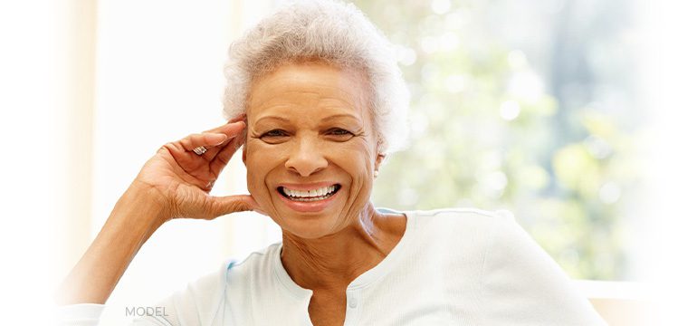 Older Female Patient Smiling and Showing Off Dental Implants